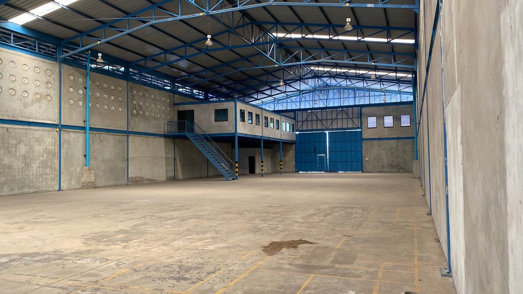 The image shows a huge empty warehouse